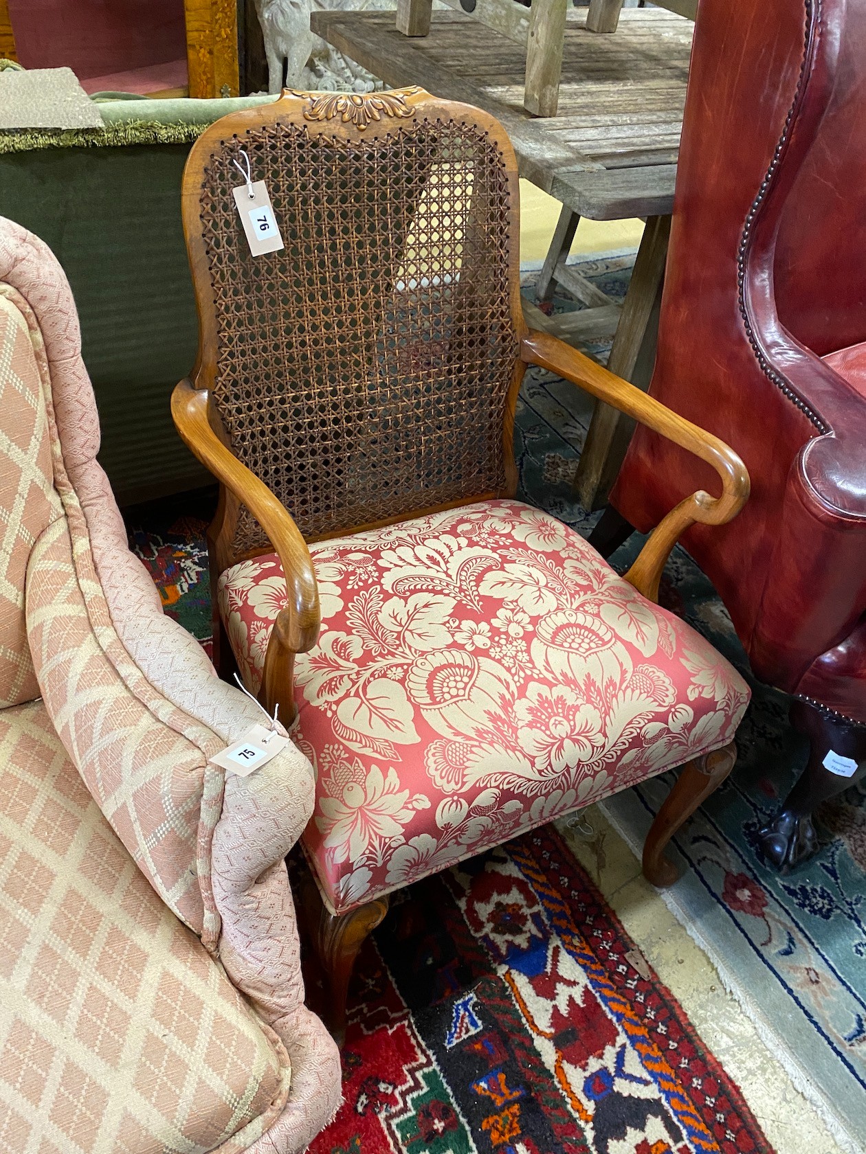 A 1920's upholstered walnut caned elbow chair, width 53cm, depth 48cm, height 88cm